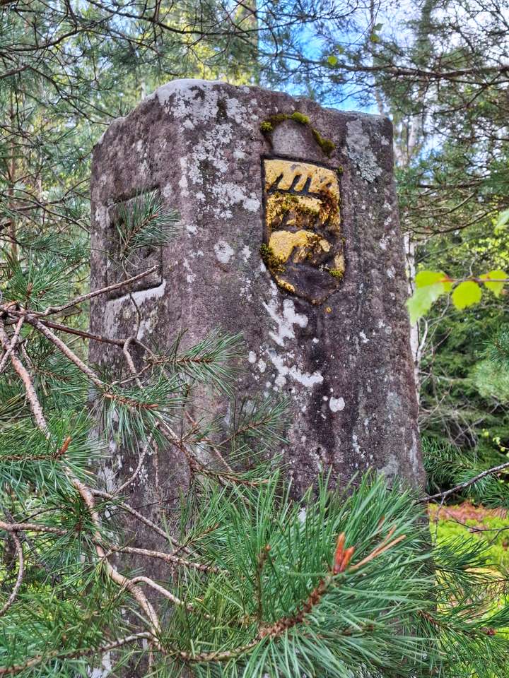 Ein alter Grenzstein, das schwäbische Logo ist schwarz und gelb angemalt
