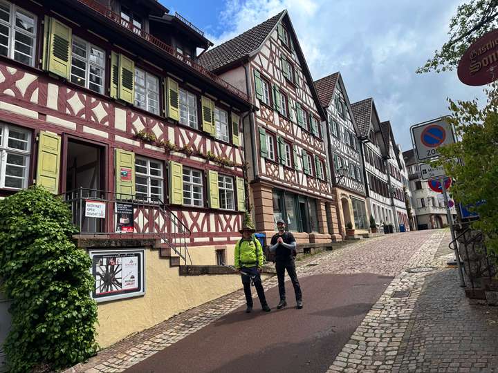 Zwei Wanderer vor Fachwerkhäusern